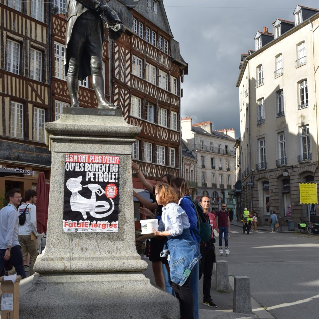 Photo de militants d'Alternatiba Rennes collant des affiches contre TotalEnergies à Rennes